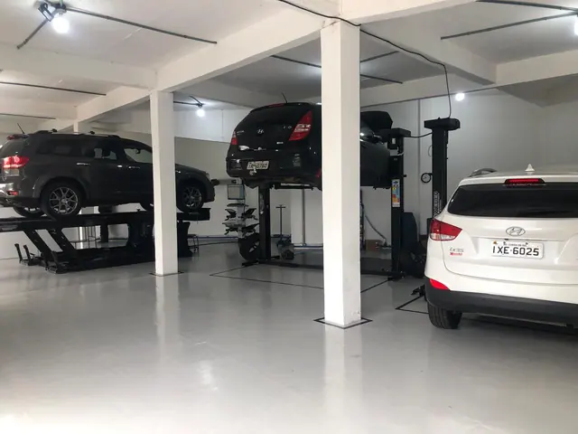 Estrutura da oficina mecânica Guerra Auto Center com carros nos elevadores